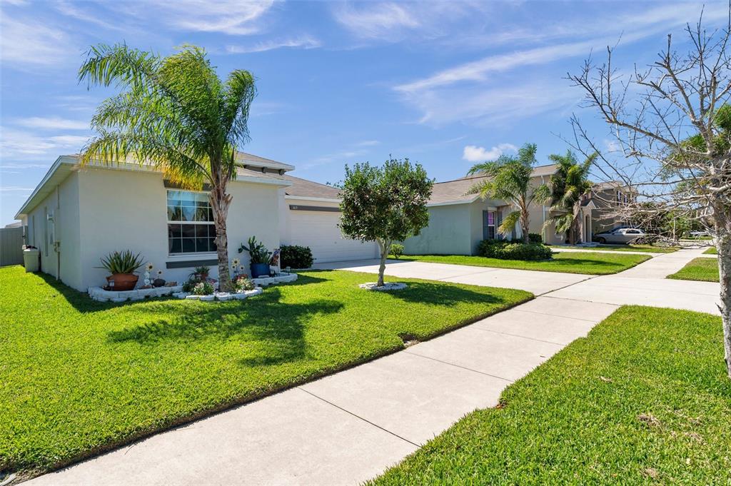 A single-story suburban house with a palm tree, manicured lawn, and concrete driveway — 1615 REDMOND BROOK LANE, RUSKIN, FL