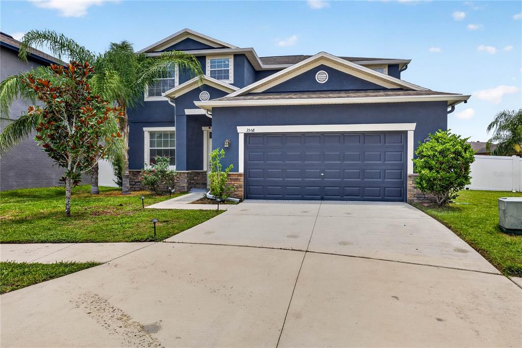 A two-story blue house with a two-car garage and a concrete driveway — 3558 BRACKNELL COURT, LAND O LAKES, FL