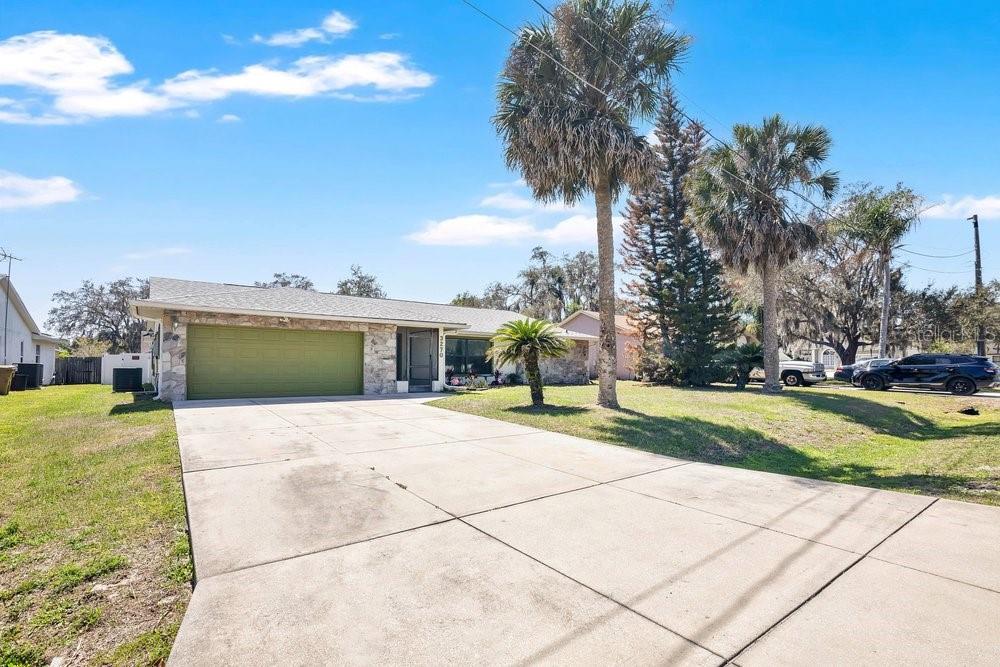 A single-story house with a green garage door and a concrete driveway — 3270 DEER LICK COURT, KISSIMMEE, FL
