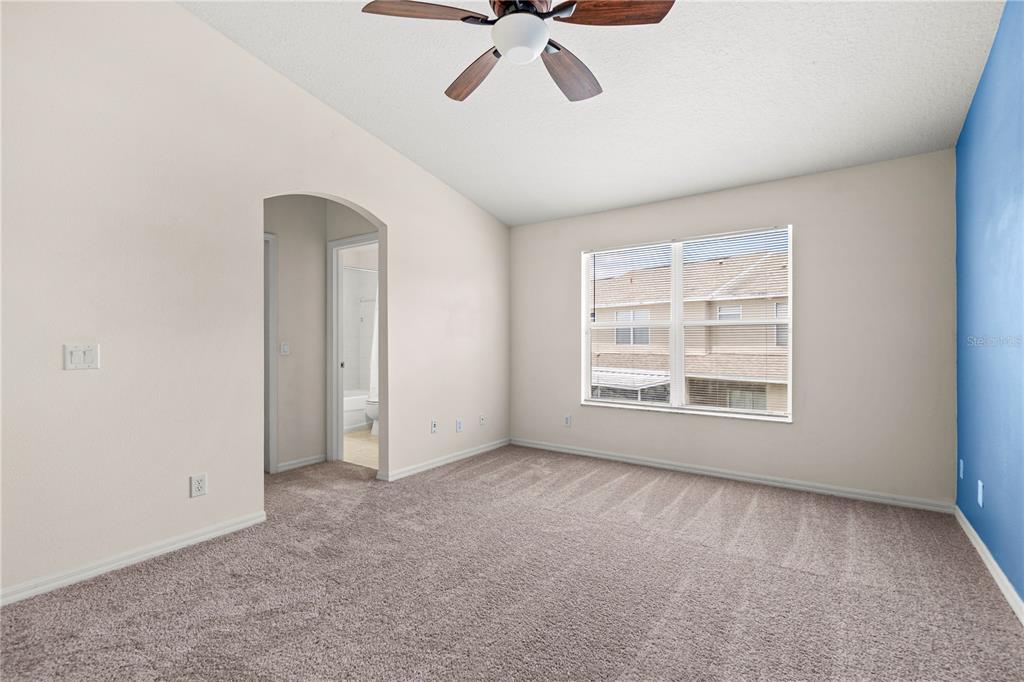 A bedroom features a blue accent wall, a platform bed, and a window seat — 3423 SANTA RITA LANE, LAND O LAKES, FL