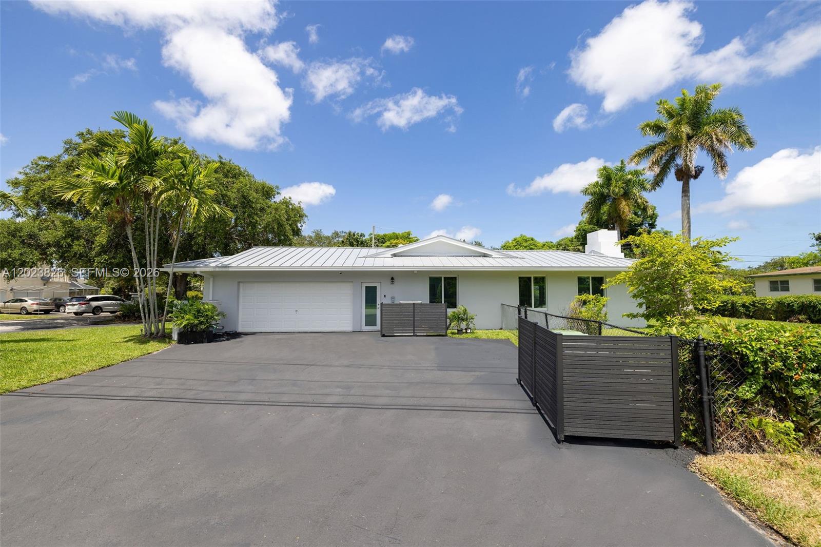 A single-story house with a white exterior, metal roof, and a paved driveway — 7980 SW 108th St, Miami FL 33156, MIAMI, FL