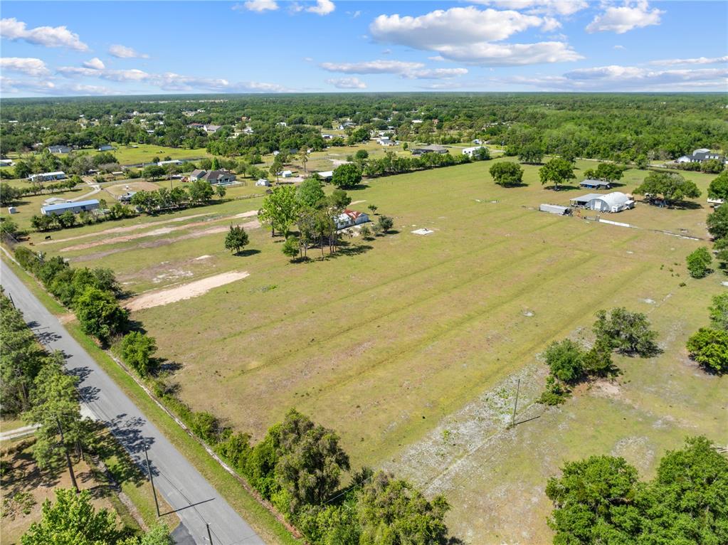 An aerial view shows a large, grassy rural lot with a house and outbuildings — 0 LA SALLE AVENUE, ST CLOUD, FL