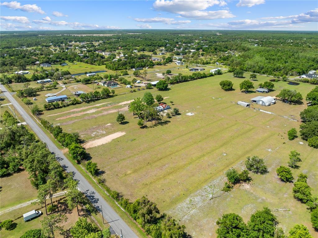 An aerial view shows a large, grassy rural property with a house and outbuildings — 0 LA SALLE AVENUE, ST CLOUD, FL