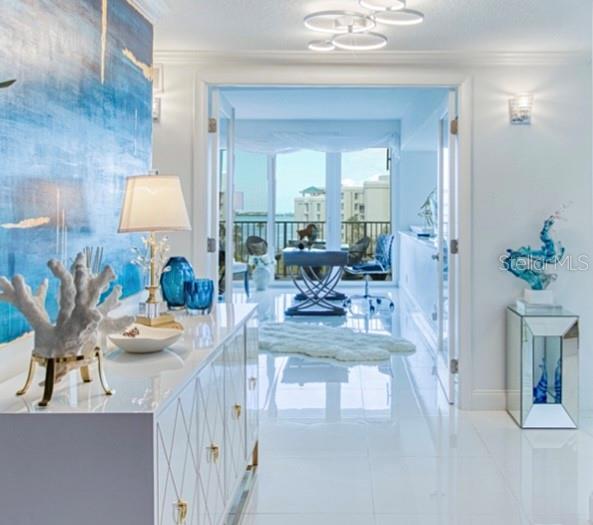 A bright foyer with white tile floors leads through glass doors to a sunlit office — 8 BELLEVIEW BOULEVARD UNIT 702, BELLEAIR, FL