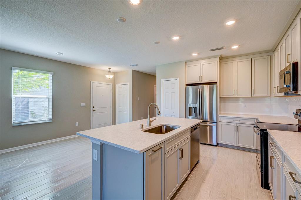 A kitchen with a central island, stainless steel appliances, and light-colored cabinetry — 5512 TRIPOLI DRIVE, PALMETTO, FL