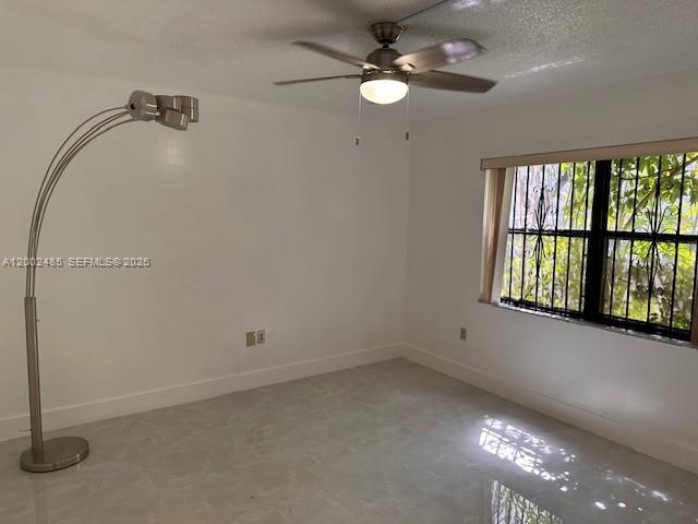 An empty room features a ceiling fan, a tall floor lamp, and a barred window — 5835 W 20th Ave # 106, Hialeah FL 33012, HIALEAH, FL