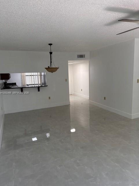 A living area with light-colored tile flooring, a breakfast bar, and a hanging light fixture — 5835 W 20th Ave # 106, Hialeah FL 33012, HIALEAH, FL