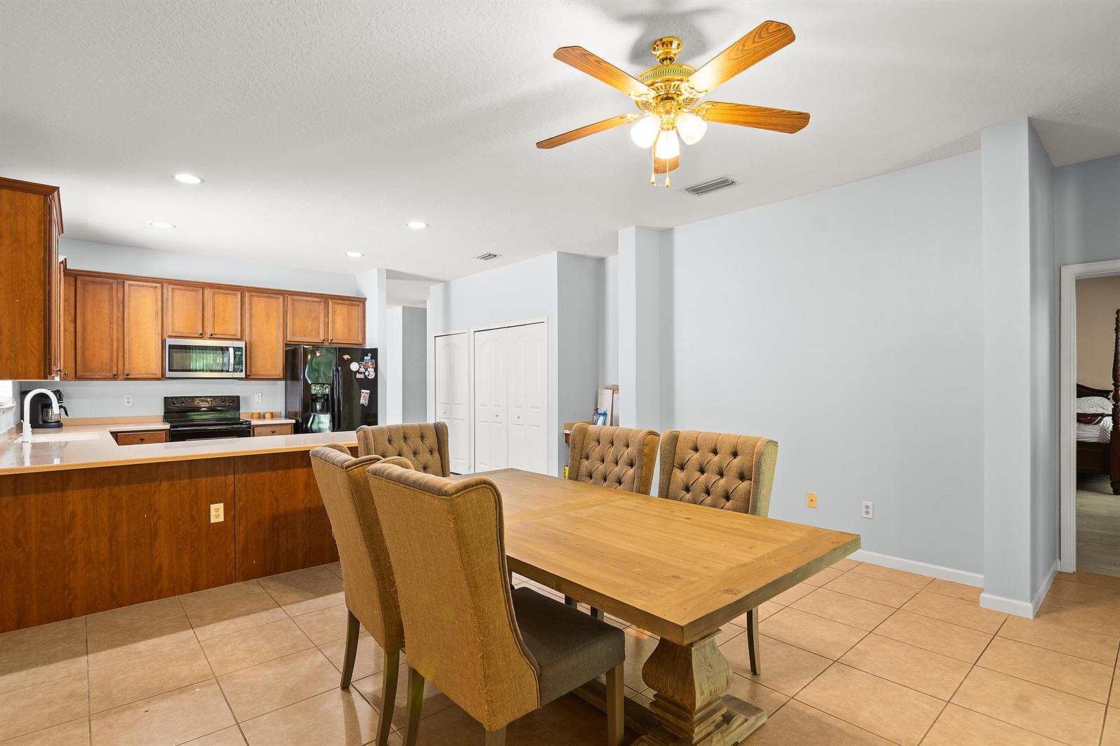 A dining area with a wooden table and upholstered chairs sits beside a kitchen counter — 504 Sebastian Crossing Boulevard, Sebastian FL 32958, SEBASTIAN, FL