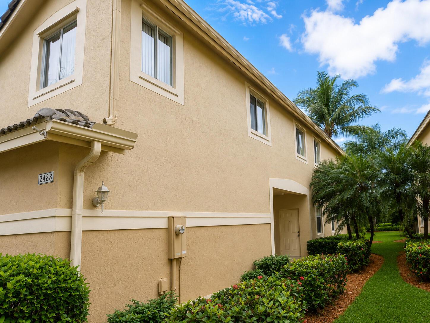 A beige two-story townhouse exterior features a side entrance, palm trees, and a landscaped lawn — 2488 Cordoba Bend, Weston FL 33327, WESTON, FL