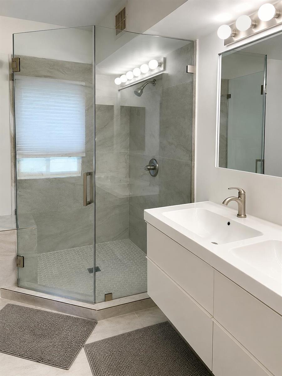 A modern bathroom features a glass-enclosed corner shower, a double vanity, and gray tile flooring — 2488 Cordoba Bend, Weston FL 33327, WESTON, FL