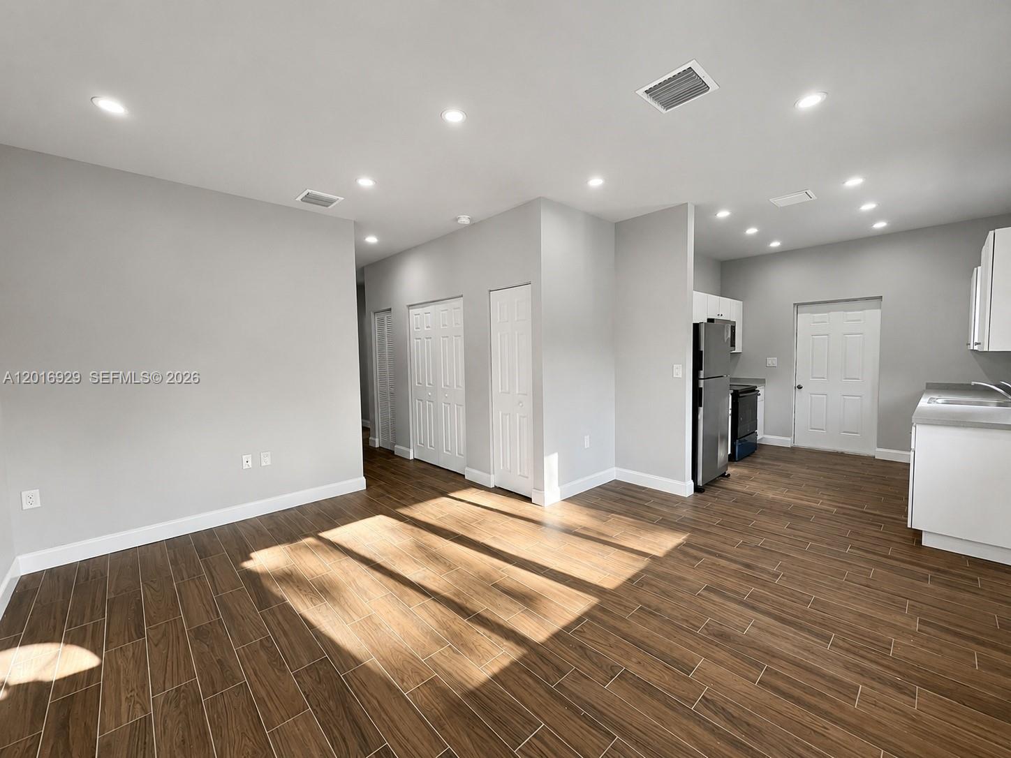 An open-concept living area features light gray walls, recessed lighting, and wood-look tile flooring — 4721 NW 15th Ct # 1, Miami FL 33142, MIAMI, FL