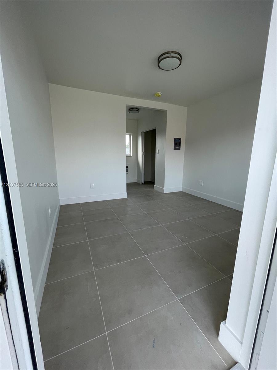 An empty room features light gray tile flooring, white walls, and a recessed doorway — 2196 Ali Baba Ave # 6, Opa-Locka FL 33054, OPA-LOCKA, FL