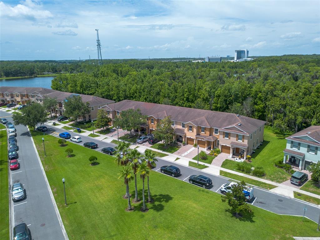 An aerial view shows a row of townhouses with parking spaces and a grassy lawn — 11191 SAVANNAH LANDING CIRCLE, ORLANDO, FL