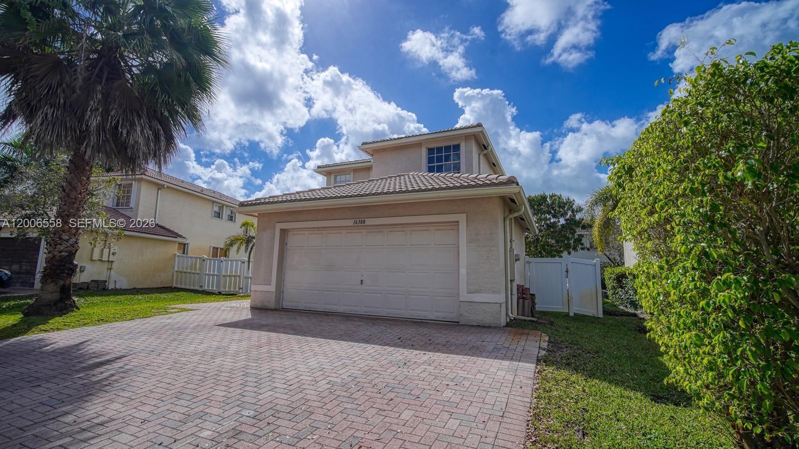 A two-story house with a beige stucco exterior and a paved driveway — 16388 SW 28th St, Miramar FL 33027, MIRAMAR, FL