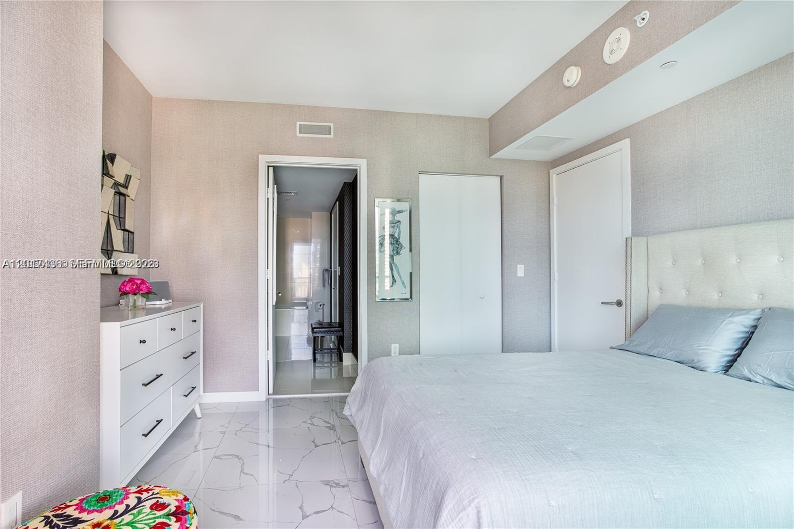 A bedroom features a white dresser, a bed with blue bedding, and a tiled floor — 1300 S Miami Ave # 2104, Miami FL 33130, MIAMI, FL