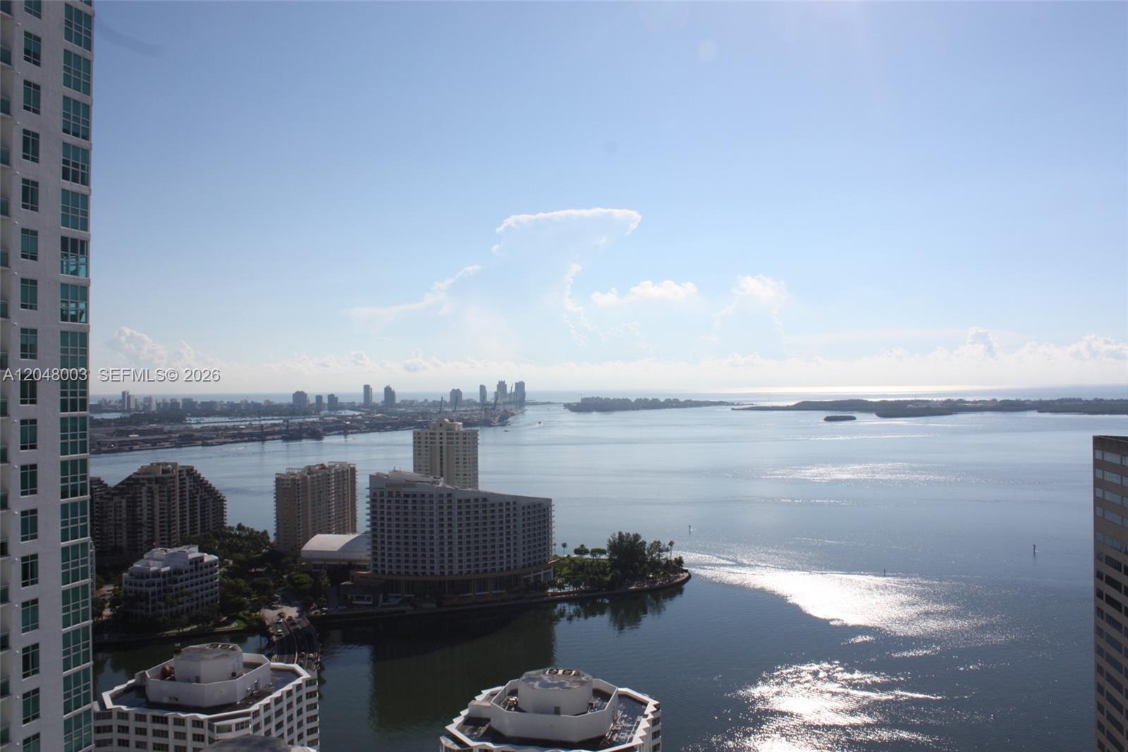 A high-angle view shows a coastal city skyline with tall buildings overlooking a bay — 951 Brickell Ave # 4006, Miami FL 33131, MIAMI, FL