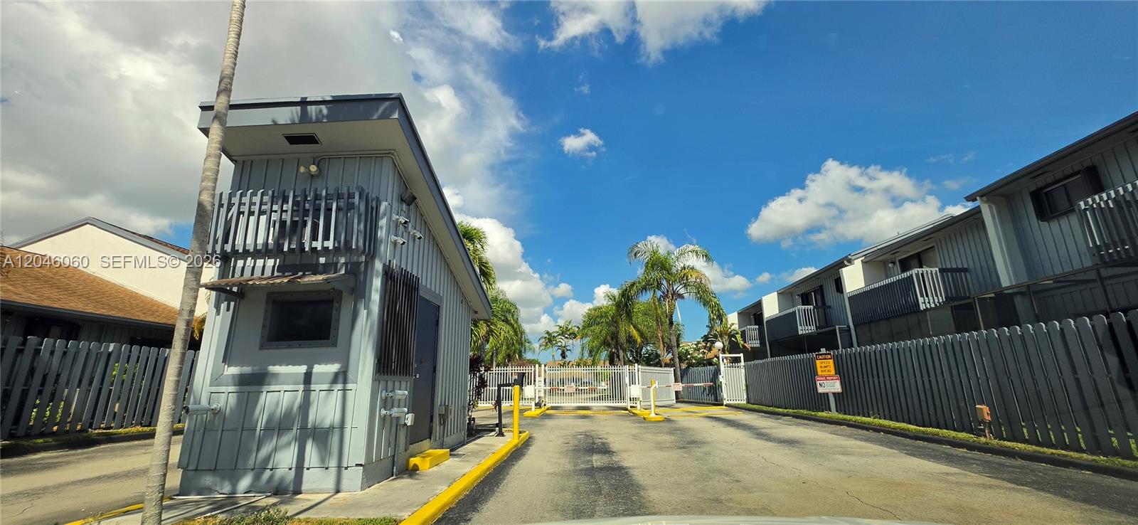 A gated entrance features a small guardhouse, a white metal fence, and surrounding residential buildings — 1652 N 14th Ter # 1652, Hollywood FL 33020, HOLLYWOOD, FL