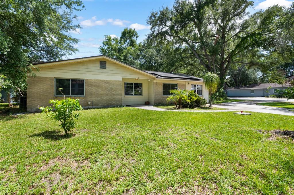 A single-story brick and siding house with a front lawn and mature trees — 201 MASON STREET, BRANDON, FL