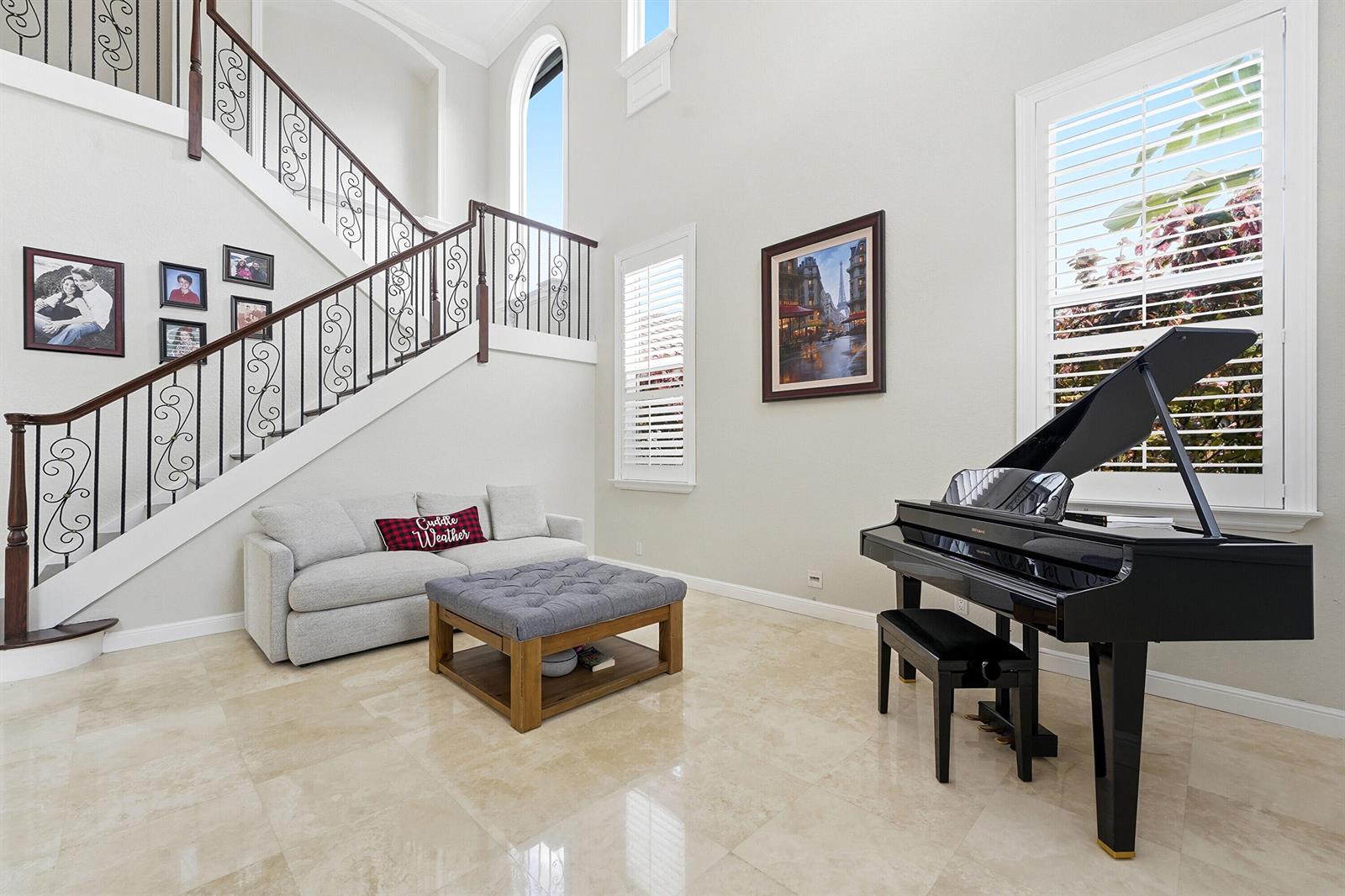 A grand foyer features a staircase with iron railings, a piano, and a sofa — 5038 NW 24th Circle, Boca Raton FL 33431, BOCA RATON, FL