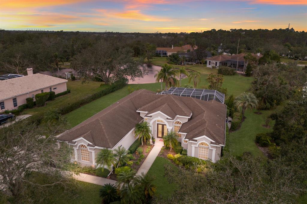 An aerial view of a single-story suburban house with a brown roof and pool enclosure — 9405 BOXTHORN PLACE, BRADENTON, FL