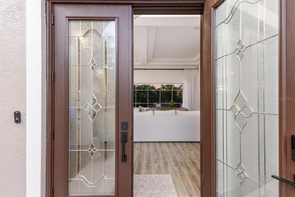 A view through an open front door into a living room with wood-look flooring — 9405 BOXTHORN PLACE, BRADENTON, FL