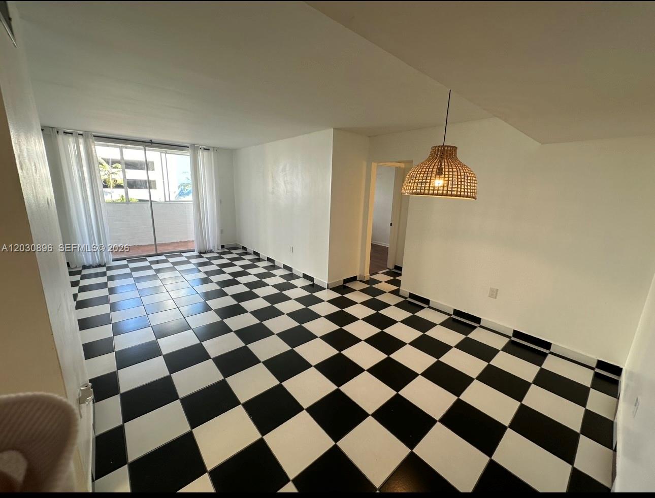 A living area features black and white checkered tile flooring and a woven pendant light — 5055 NW 7th St # 409, Miami FL 33126, MIAMI, FL