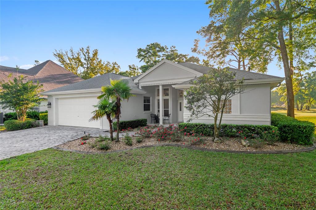 A single-story house with a white exterior, a two-car garage, and a landscaped front yard — 10801 SW 71ST AVE, OCALA, FL