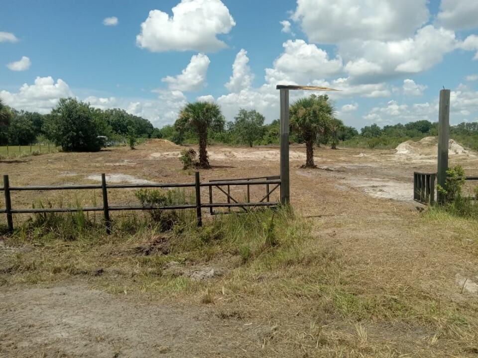 A fenced, cleared dirt lot features two palm trees and a wooden gate entrance — 19145 NW 270th Street, Okeechobee FL 34972, OKEECHOBEE, FL