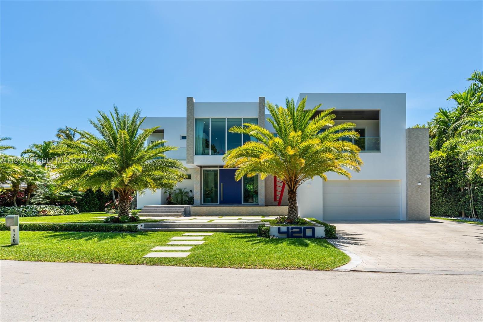 A modern two-story house features a large front door, palm trees, and a paved driveway — 420 Island Dr, Key Biscayne FL 33149, KEY BISCAYNE, FL