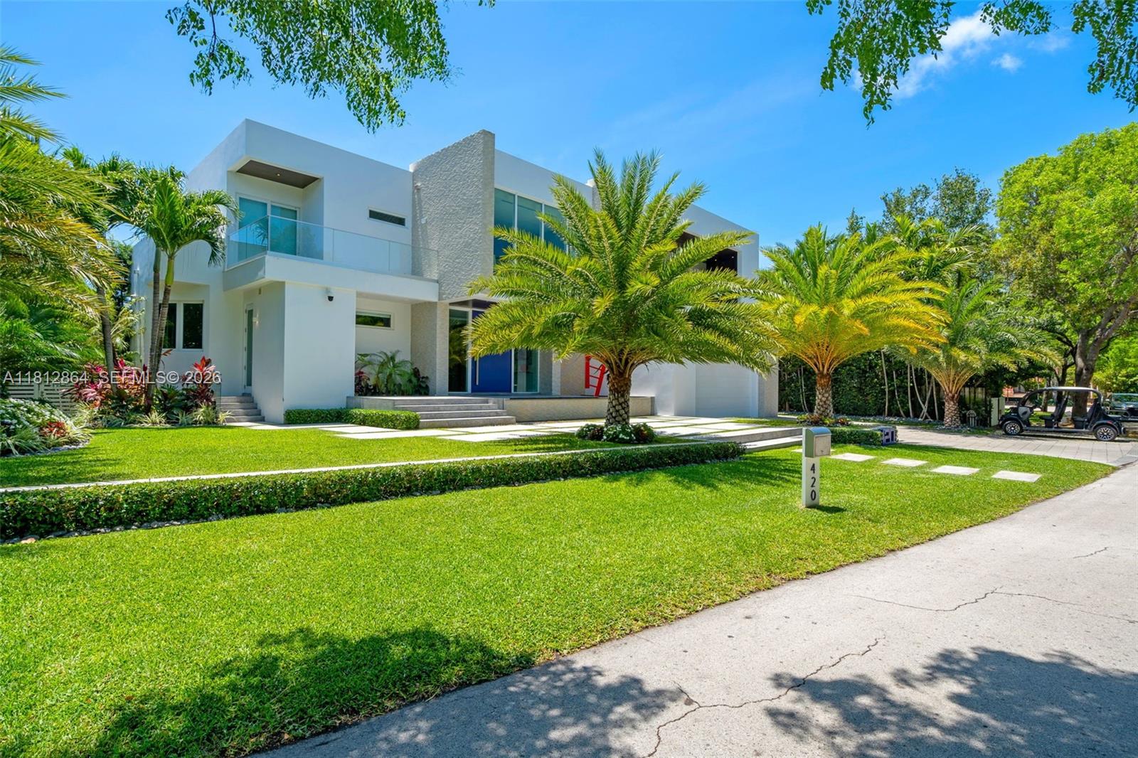 A modern two-story house with a blue front door, palm trees, and a paved driveway — 420 Island Dr, Key Biscayne FL 33149, KEY BISCAYNE, FL