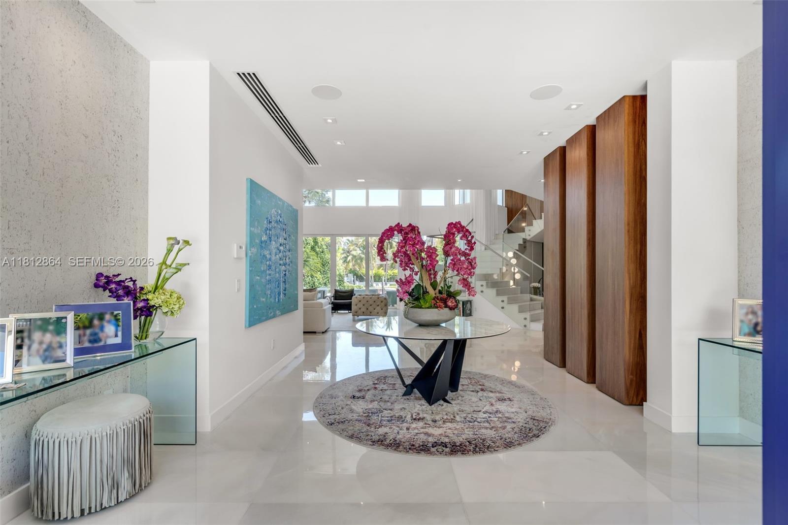 A bright foyer features a glass console table, a central pedestal table, and a staircase — 420 Island Dr, Key Biscayne FL 33149, KEY BISCAYNE, FL
