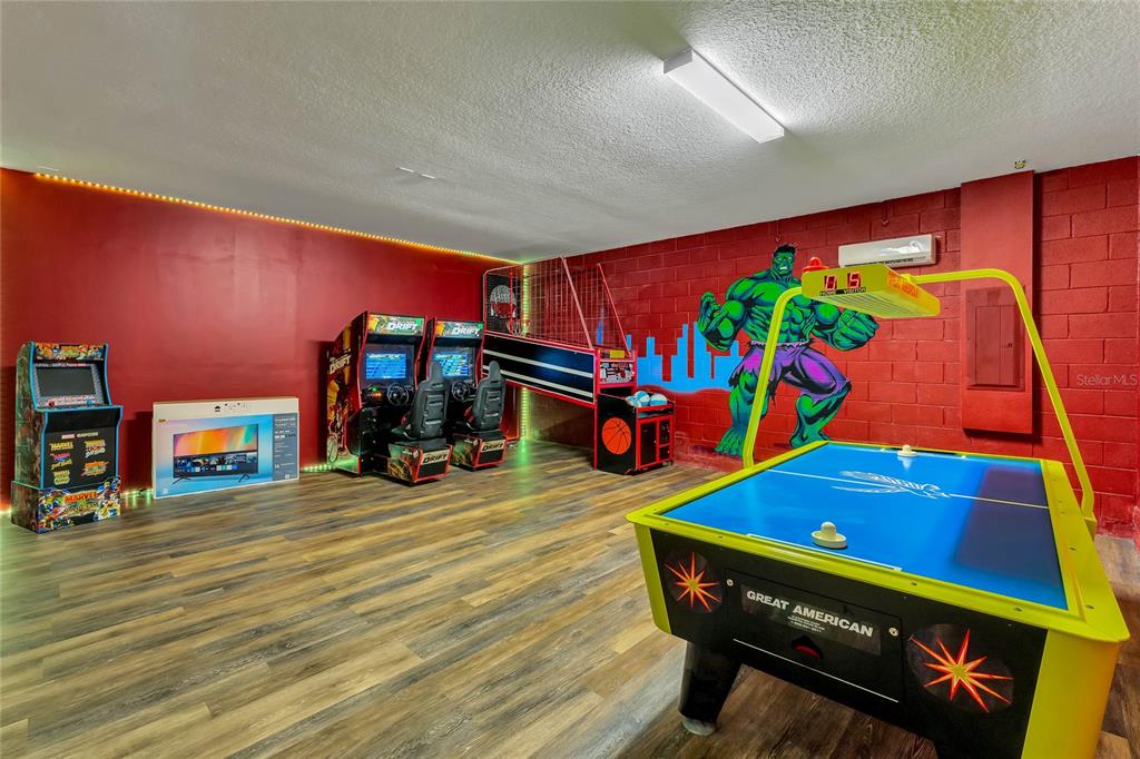 A game room features arcade machines, a basketball hoop game, an air hockey table, and Hulk mural — 7517 MARKER AVENUE, KISSIMMEE, FL