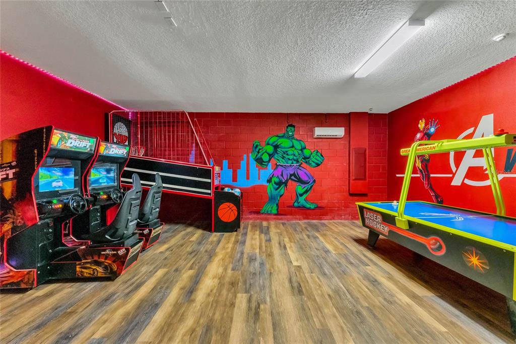 A game room features arcade racing machines, a basketball hoop, and an air hockey table — 7517 MARKER AVENUE, KISSIMMEE, FL