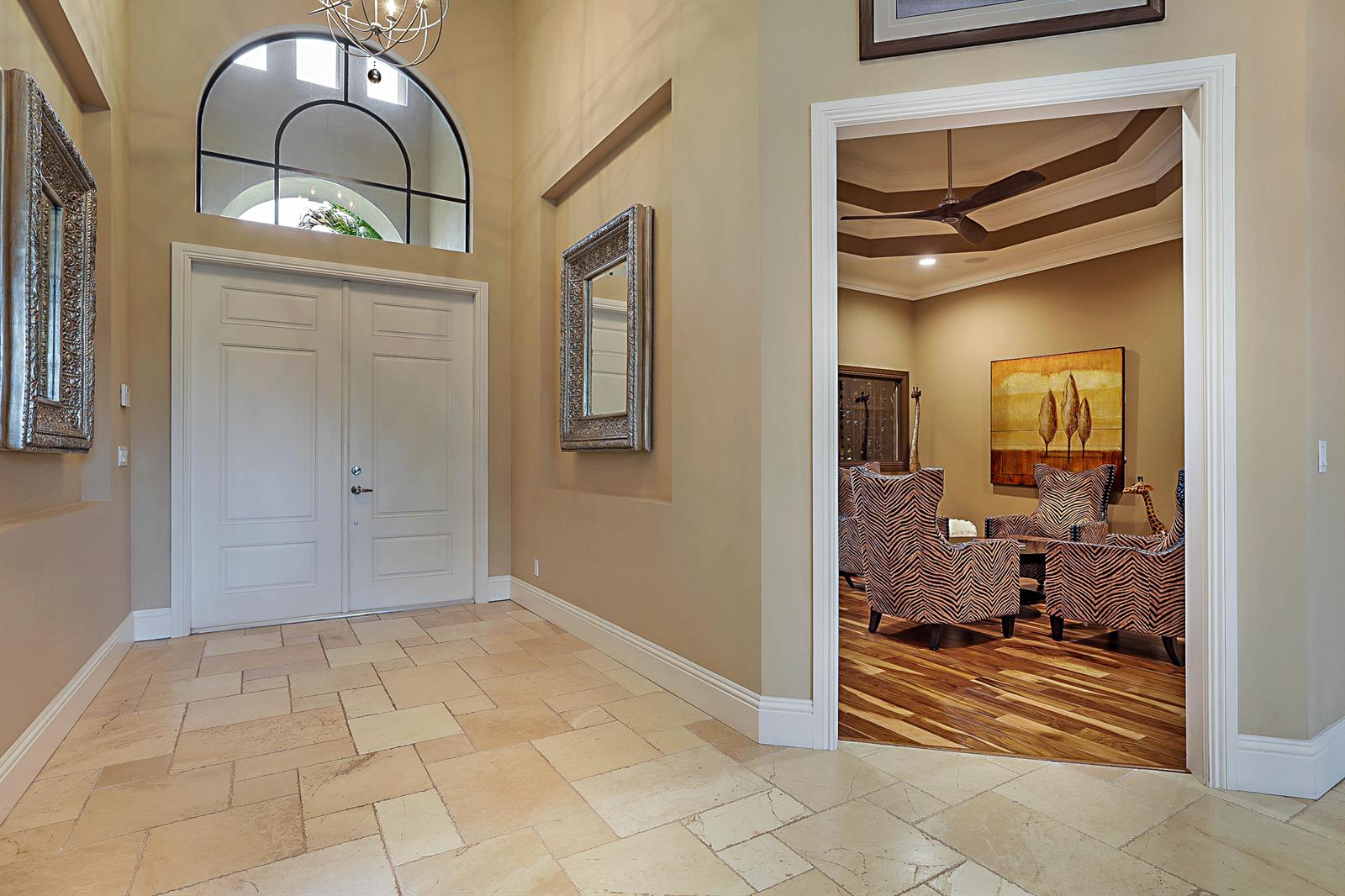 A foyer with stone flooring and double doors leads into a room with zebra-print chairs — 18337 SE Old Trail Drive W, Jupiter FL 33478, JUPITER, FL