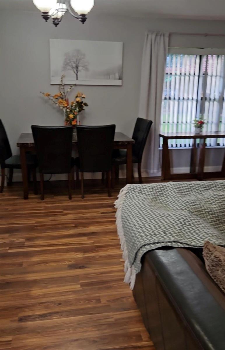 A dining area with a wooden table, dark chairs, and wood-look flooring — 9215 W Sunrise Boulevard, Plantation FL 33322, PLANTATION, FL