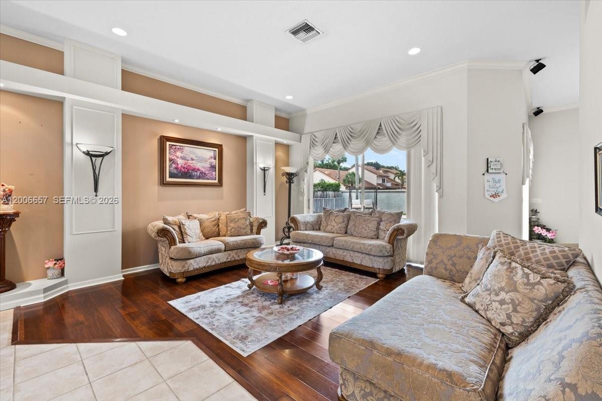 A living room features hardwood floors, a patterned area rug, and three upholstered sofas — 10912 NW 2nd St, Plantation FL 33324, PLANTATION, FL