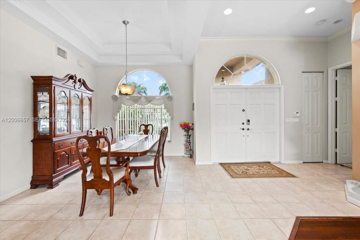 A dining room features a wooden table, a matching hutch, and a double-door entryway — 10912 NW 2nd St, Plantation FL 33324, PLANTATION, FL