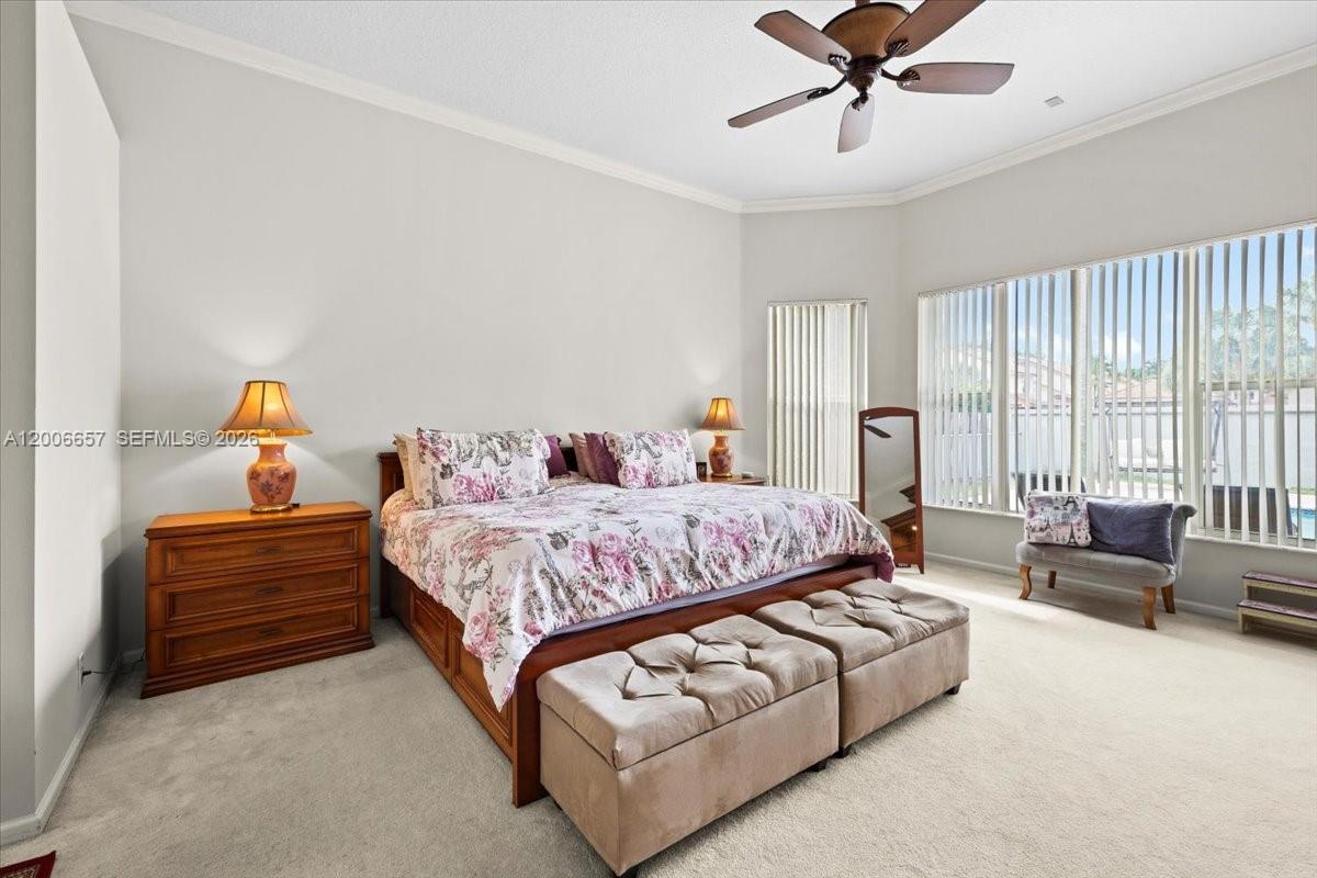 A bedroom features a floral bedspread, two matching ottomans, and large windows with blinds — 10912 NW 2nd St, Plantation FL 33324, PLANTATION, FL