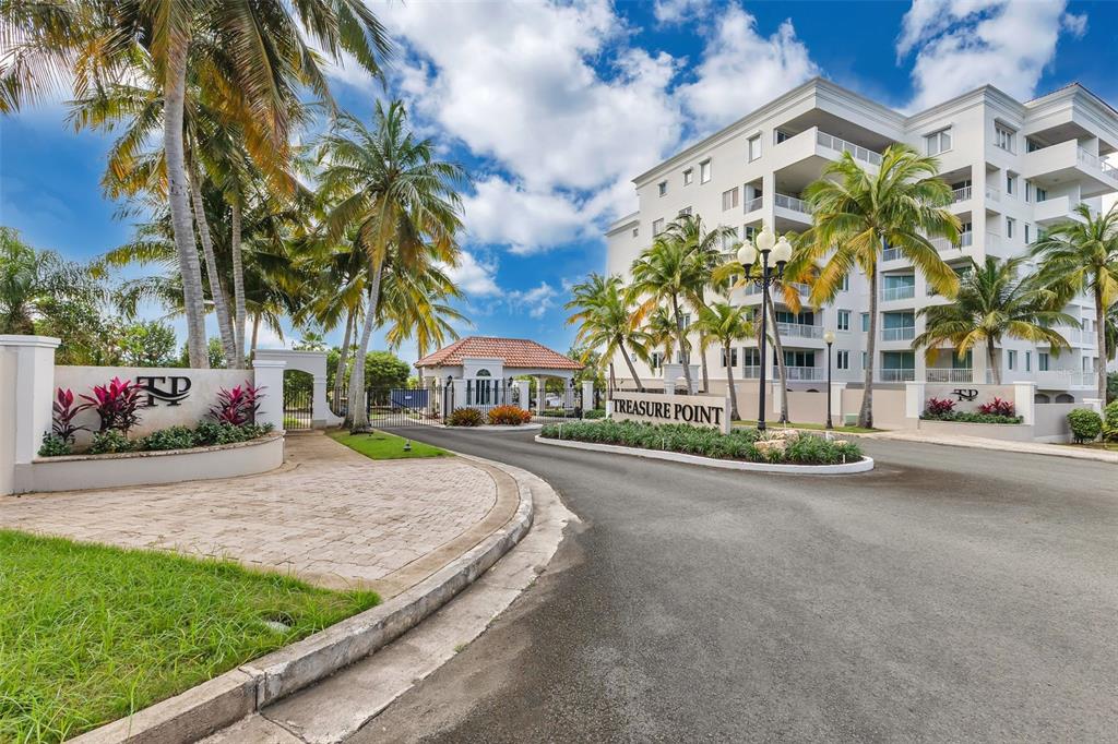 The gated entrance to the Treasure Point residential complex features palm trees and a building — 324 CALLE OLIVINE UNIT 324, VEGA ALTA, PR