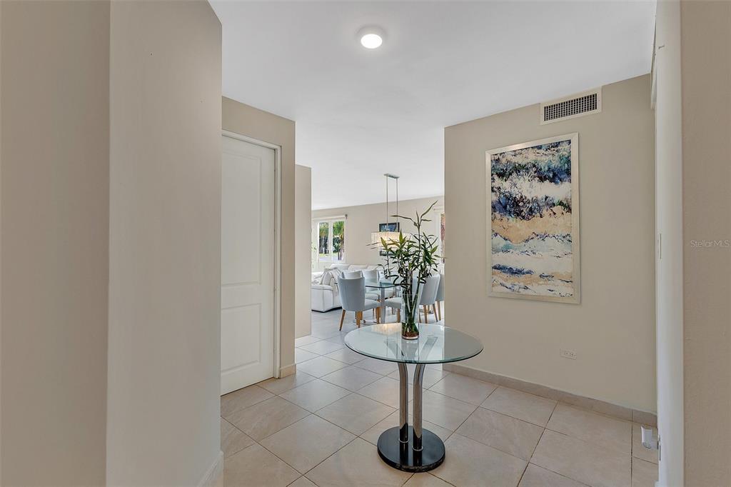 A tiled entryway features a glass pedestal table and leads into a dining area — 324 CALLE OLIVINE UNIT 324, VEGA ALTA, PR
