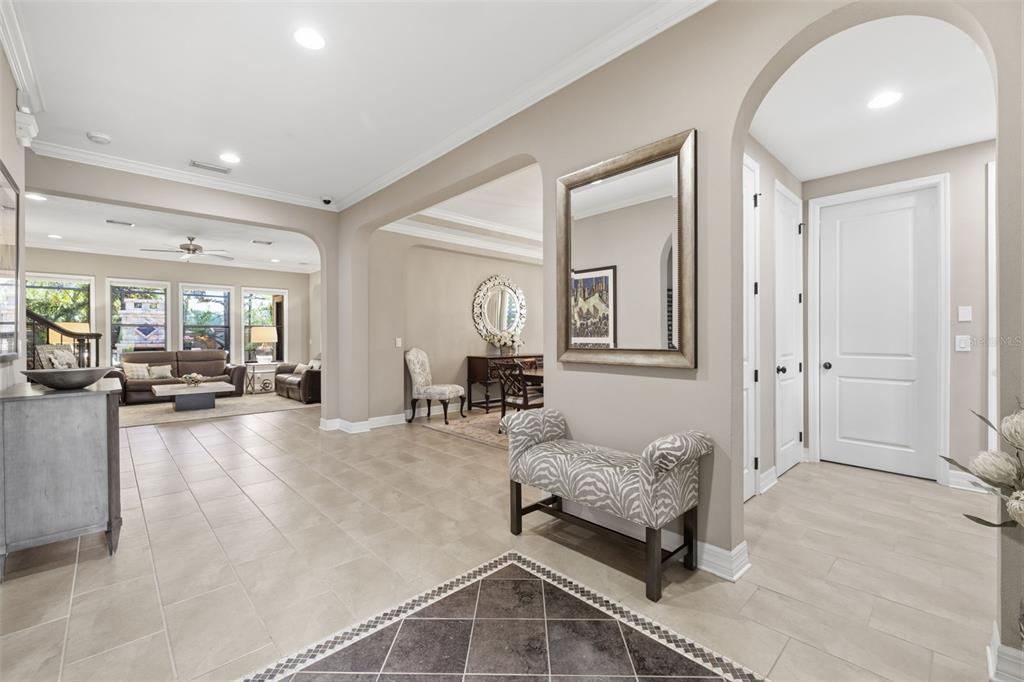 A tiled entryway features a zebra-print bench, a wall mirror, and an arched doorway — 14231 AVON FARMS DRIVE, TAMPA, FL