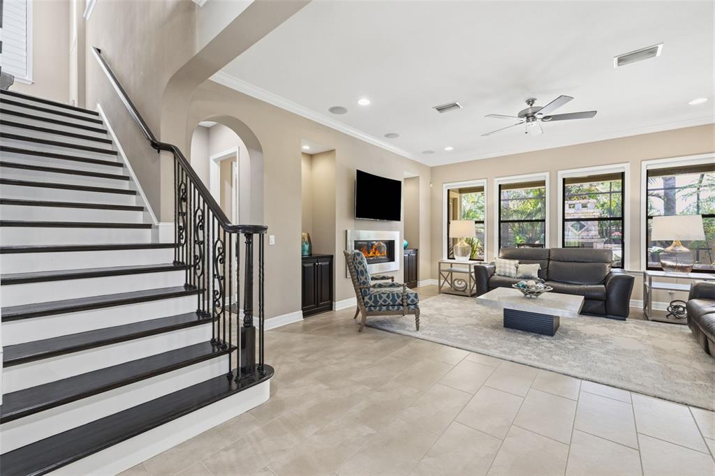 A living room features a staircase, fireplace, television, and tile flooring — 14231 AVON FARMS DRIVE, TAMPA, FL