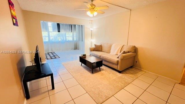 A living room features a beige sofa, a coffee table, and white tile flooring — 6500 Cypress Rd # 402, Plantation FL 33317, PLANTATION, FL