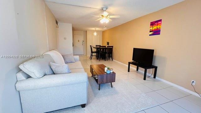 A living room with a light-colored sofa, a coffee table, and a dining area beyond — 6500 Cypress Rd # 402, Plantation FL 33317, PLANTATION, FL