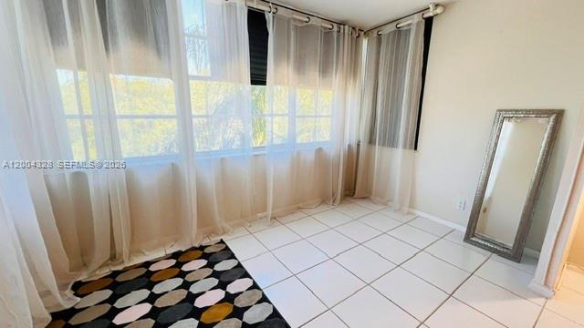 A sunroom with white tile flooring, sheer curtains, and a floor-length mirror — 6500 Cypress Rd # 402, Plantation FL 33317, PLANTATION, FL