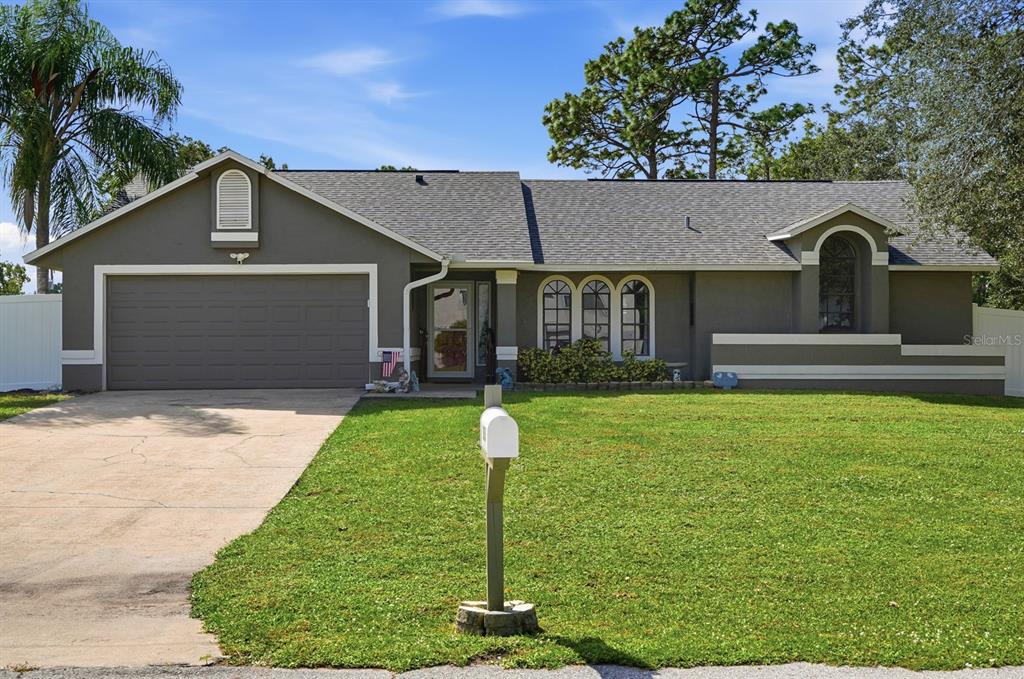 A single-story house with a gray exterior, a two-car garage, and a front lawn — 3153 BYINGTON TERRACE, DELTONA, FL