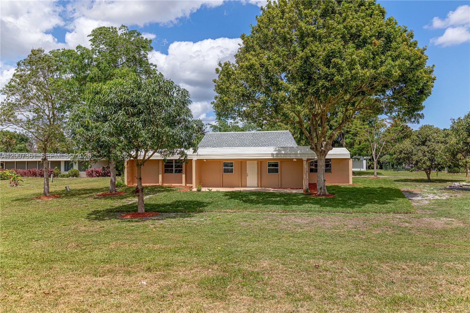 A single-story tan brick house with a white roof sits on a grassy lot — 5201 Yellow Pine Ln, Tamarac FL 33319, TAMARAC, FL