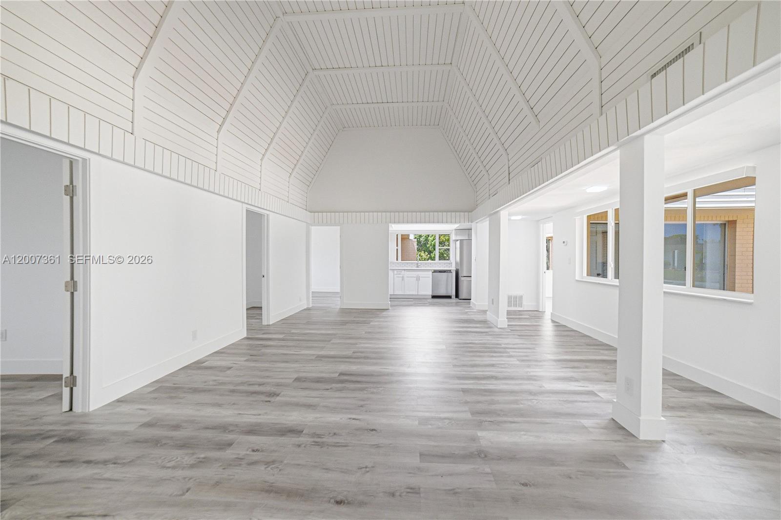 A bright, open-concept living area features a vaulted plank ceiling and light wood-look flooring — 5201 Yellow Pine Ln, Tamarac FL 33319, TAMARAC, FL