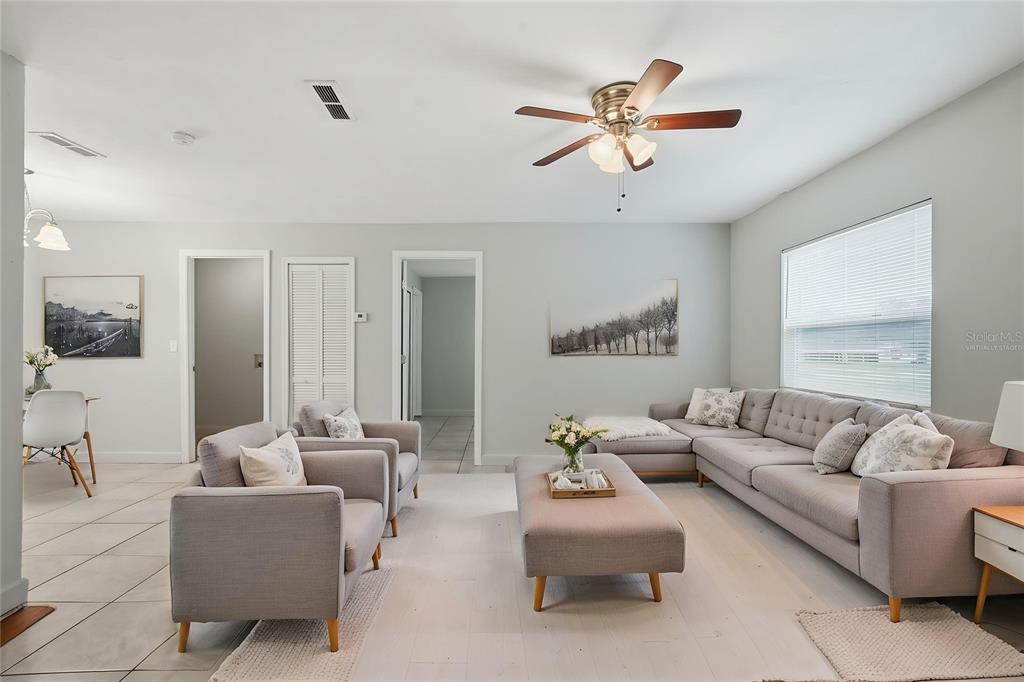 A living room with light gray walls, tile flooring, a sectional sofa, and a ceiling fan — 956 OSCEOLA TRAIL, CASSELBERRY, FL