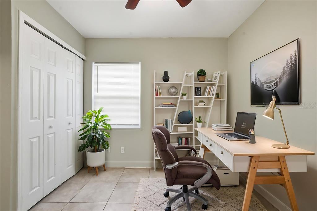 A home office features a desk, rolling chair, white shelving, a potted plant, and tile flooring — 956 OSCEOLA TRAIL, CASSELBERRY, FL
